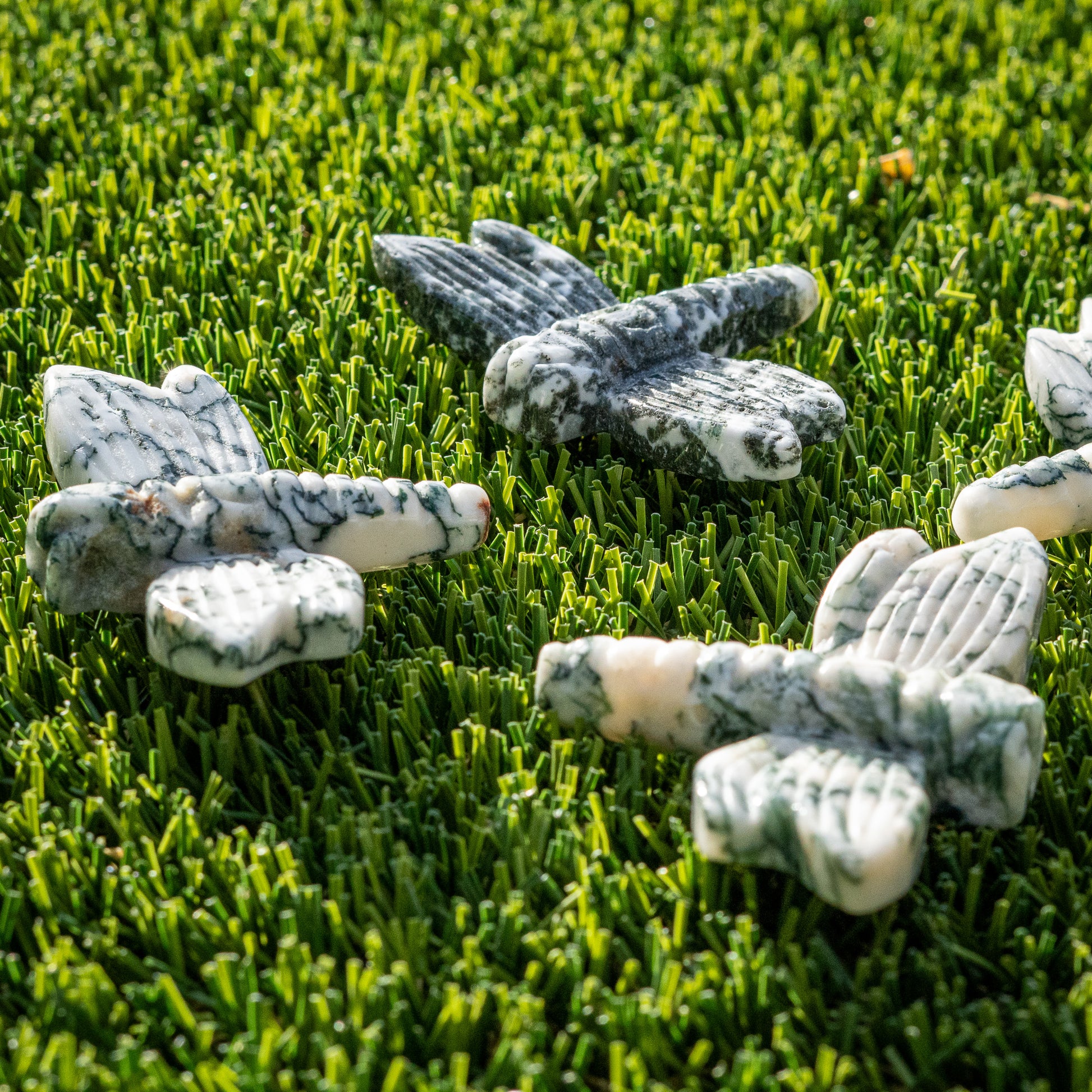 Decorative stone butterflies on artificial grass