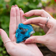 Chrysocolla from Arizona being held by hands. chrysocolla is a stone used to open the throat chakra and enhances speaking out about what is real alive and true. 