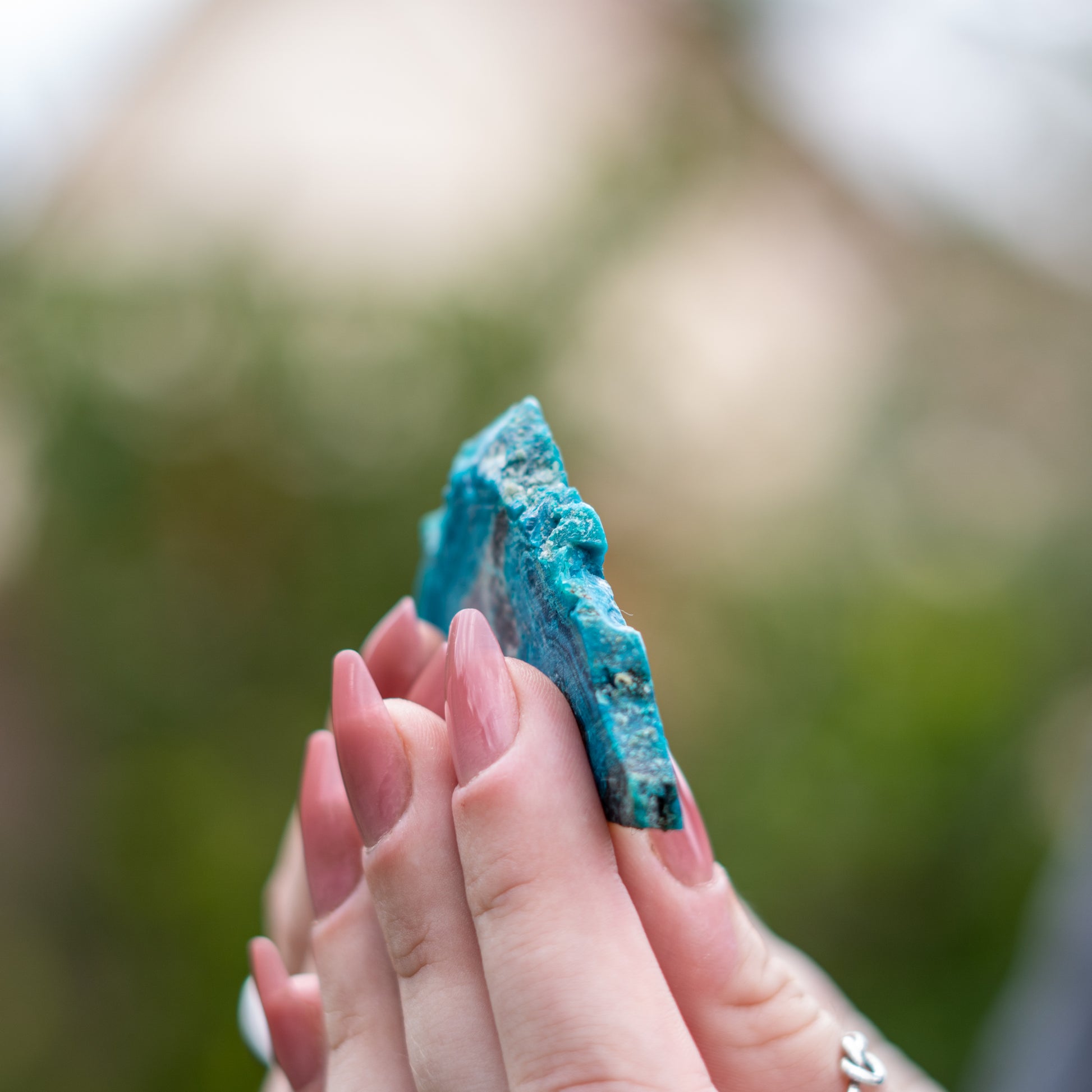 Chrysocolla crystal from Arizona being held in the hands of an energy worker. Chrysocolla is good for feminine hormone balance. 